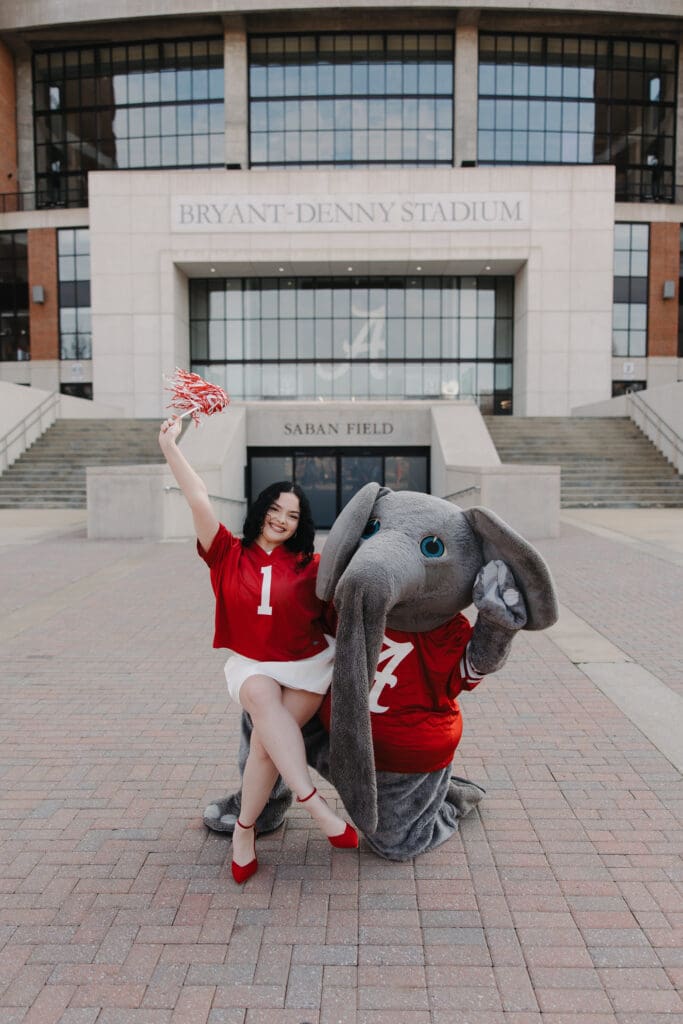 University of Alabama graduate posing with Big Al mascot and shaker at Bryant-Denny Stadium in Tuscaloosa Alabama